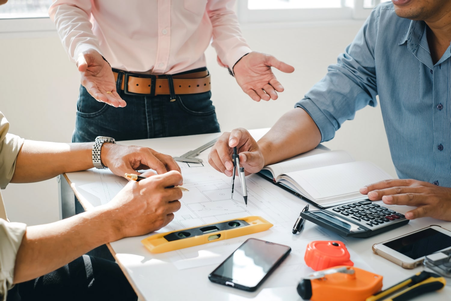 engineer and contractor planning projects together at desk with